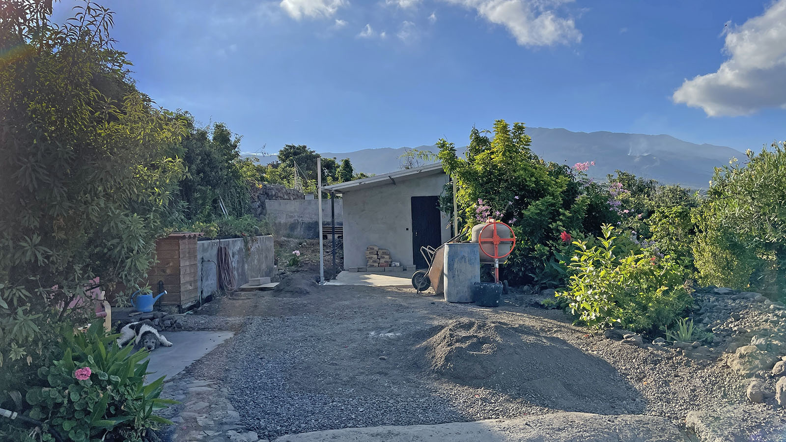 Oude erf met losse steentjes en links het terras van de casita met zwarte tegels